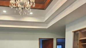 A living room with a dining table, chairs, a TV stand, and a fan. - Room in Guest Room - Stunning Home Great Location (Pattaya)