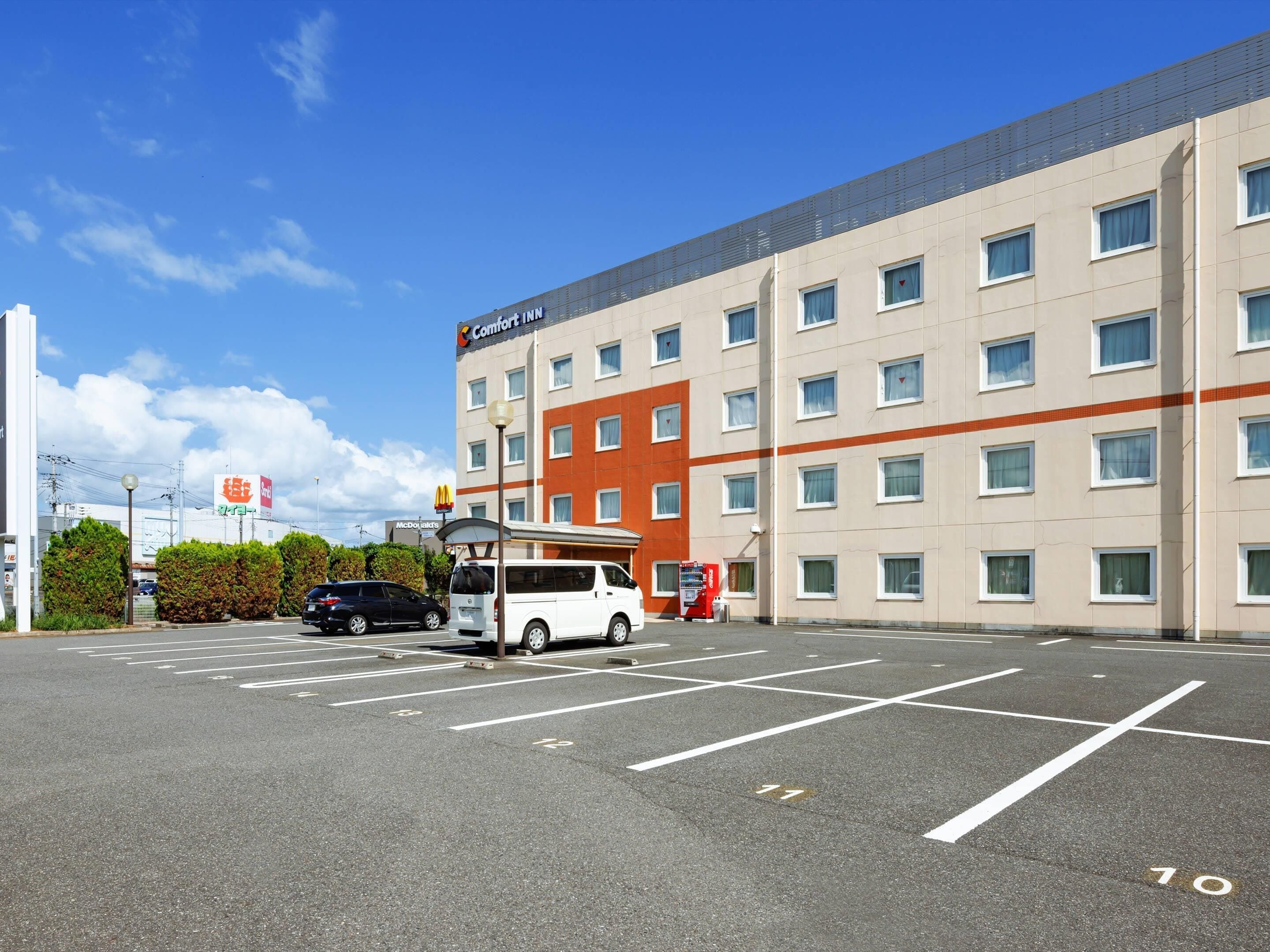 A hotel with a parking lot, a McDonald's sign, and a Comfort Inn sign.