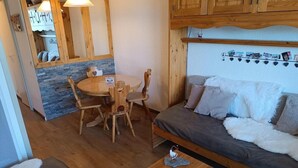 Ett mysigt vardagsrum med en soffa, ett matbord med stolar och ett litet soffbord.