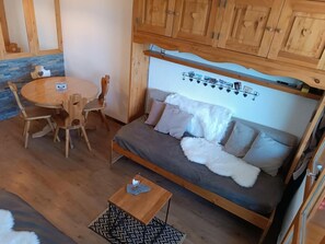 A cozy room with a wooden sofa, a round wooden table, and matching chairs. - 200m from ski slopes, balcony, tv, ski locker, 22m², Montchavin La Plagne (Bellentre)