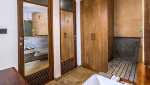 A bathroom with wooden cabinets, a bathtub, and a shower area.