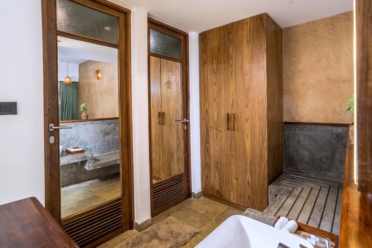 A bathroom with wooden cabinets, a bathtub, and a shower area.