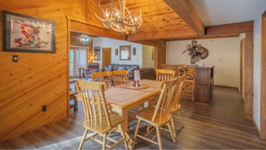 A wooden interior with a dining area, wooden ceiling beams, and a chandelier. - Byrd Mountain - Upper Canyon Gem - Large Game Room (Ruidoso)