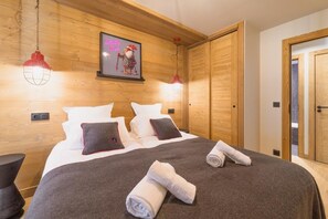 Un dormitorio con paneles de madera, una cama, almohadas y un cuadro en la pared.