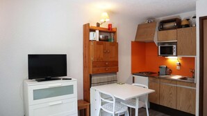 A compact kitchenette with a microwave, stove, and small dining table. - 10m from ski slopes, 2nd floor, balcony, ski locker, 24m², Les Orres (Les Orres)