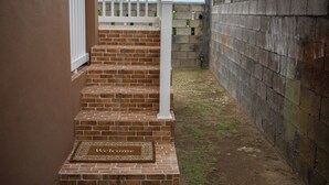 A set of brick stairs with a welcome mat at the bottom. - Modern Comfort: Private 1BR In Basseterre (Basseterre)