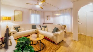 A modern living room with a sofa, coffee table, and a ceiling fan.