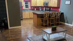 A modern kitchen with wooden cabinets, a central island, and bar stools. - Cozy building in charming Loretto with WiFi, AC (Loretto)