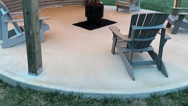 A covered outdoor seating area with wooden chairs and a fire pit. - Cozy building in charming Loretto with WiFi, AC (Loretto)