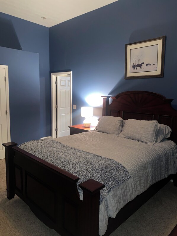A bedroom with a bed, a nightstand, a lamp, and a framed picture on the wall. - Cozy building in charming Loretto with WiFi, AC (Loretto)