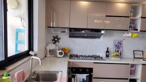 A modern kitchen with a sink, stove, and various kitchen appliances. - Lenayan Park View Deluxe Double Room (Nairobi)