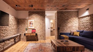 A cozy living room with a blue sofa, wooden coffee table, and a patterned rug. - Industrial Loft Duplex (100sqm) near Antonplatz (Berlin)