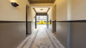 A hallway with patterned flooring, a star design, and a view of a yellow bus outside. - Industrial Loft Duplex (100sqm) near Antonplatz (Berlin)