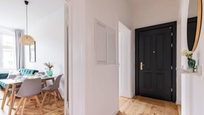 A modern interior with a dining area, a black door, and a mirror on the wall. - 75sqm flat 1st occupancy, near centre & PrenzlBerg (Berlin)