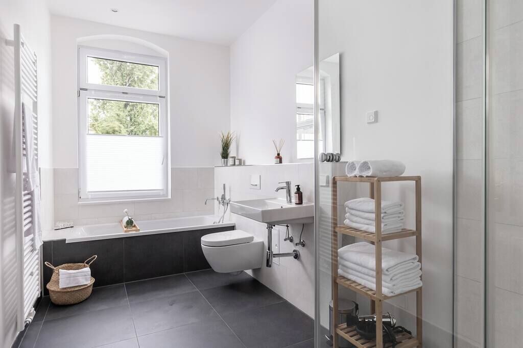 Une salle de bain moderne avec une baignoire, des toilettes et une douche à l’italienne.