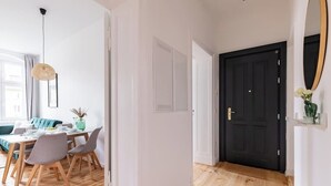 Een modern interieur met een eethoek, een zwarte deur en een spiegel aan de muur.