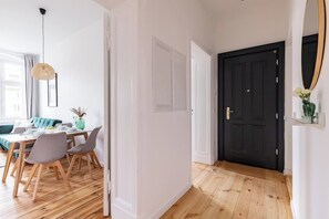 A modern interior with a dining area, a black door, and a mirror on the wall. - 75sqm flat 1st occupancy, near centre & PrenzlBerg (Berlin)