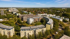 A residential area with multi-story buildings, a curved structure, and a river.