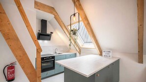 A modern kitchen with a skylight, a built-in oven, and a welcome sign indicating Berlin. - Bright Hideaway (70 sqm) near BER Airport (Berlin)