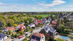 Et boligområde med huse, en vej og en grøn mark.