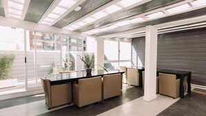 A modern office space with a long table, several chairs, and a potted plant. - Maison Work & Travel 6 - Palermo  (Buenos Aires)