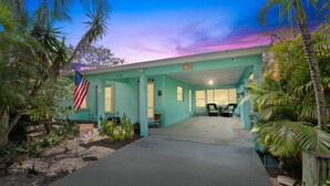 Een turquoise gebouw met een overdekte oprit en een vlag.