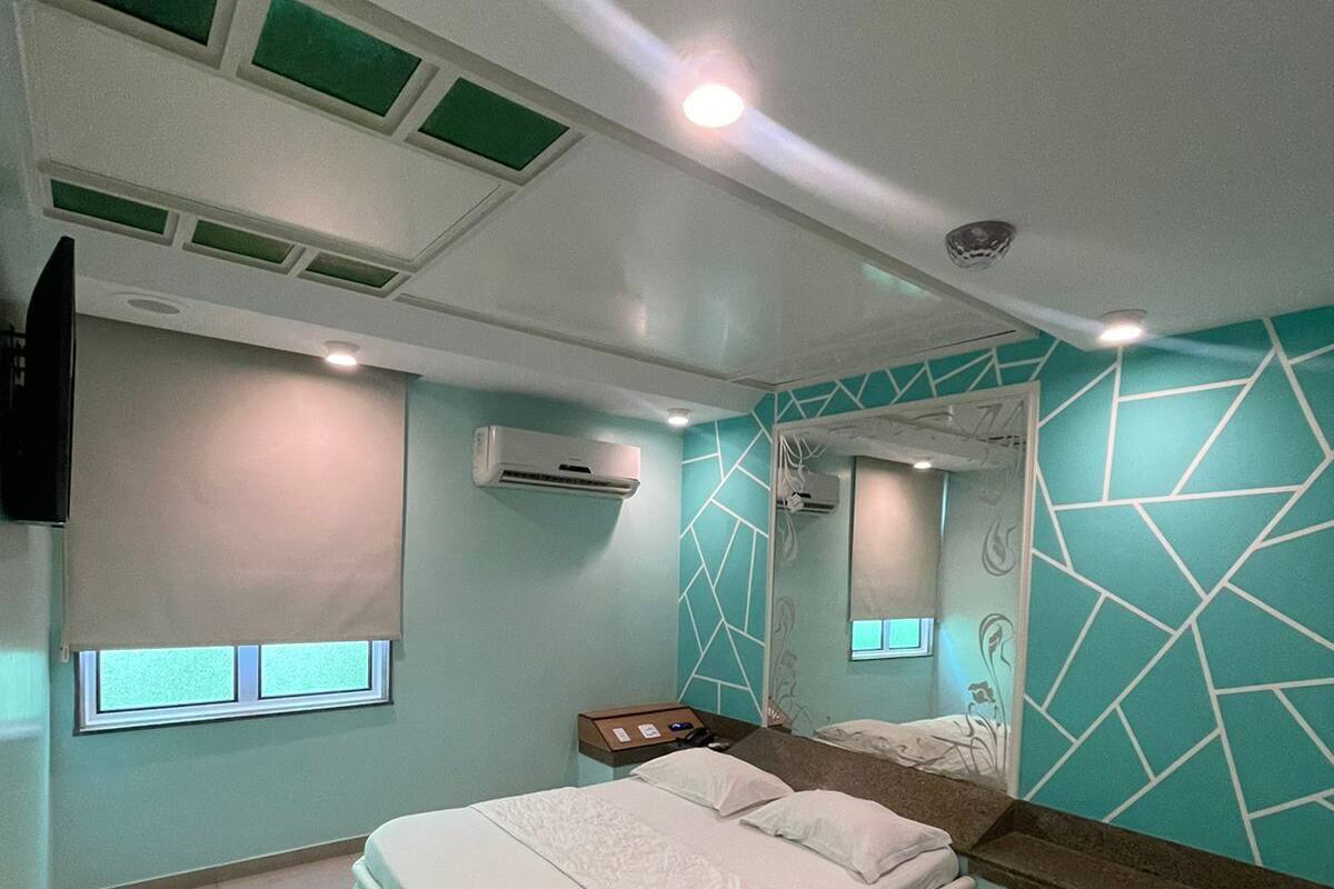Un dormitorio moderno con cama, mesita de noche, espejo y ventana.