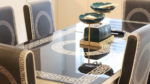 A dining table with a geometric pattern, surrounded by chairs with similar designs.