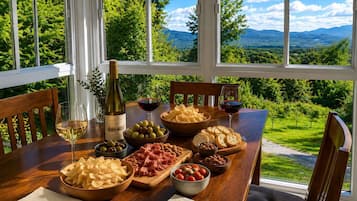 Une table à manger avec une bouteille de vin, des verres et diverses collations.