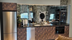 A modern kitchen with a built-in dishwasher, a refrigerator, and a microwave.