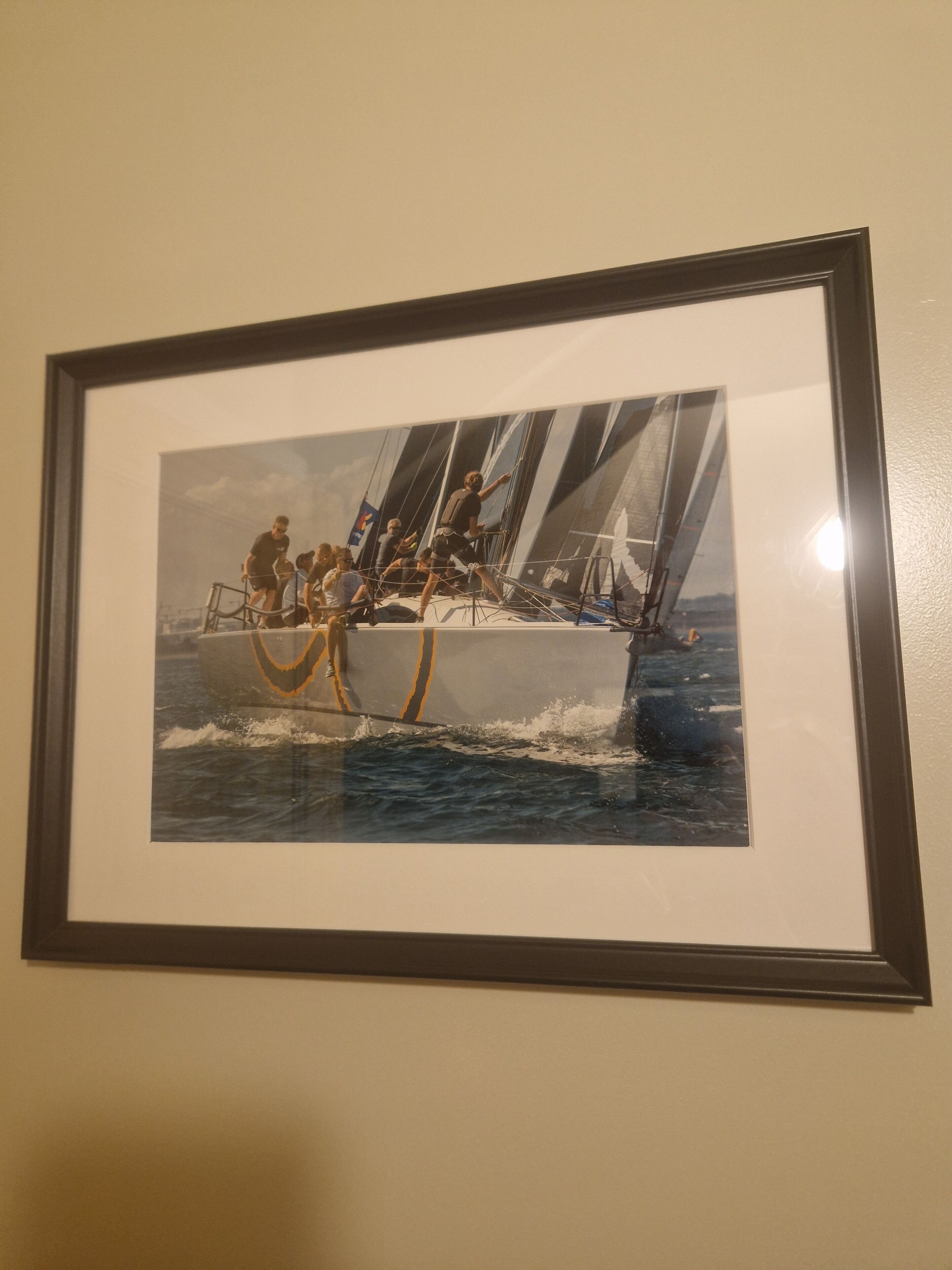 Fotografia amb marc d'una embarcació de vela amb persones al pont.
