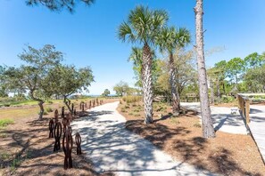 A paved pathway in a park with trees and wooden structures.