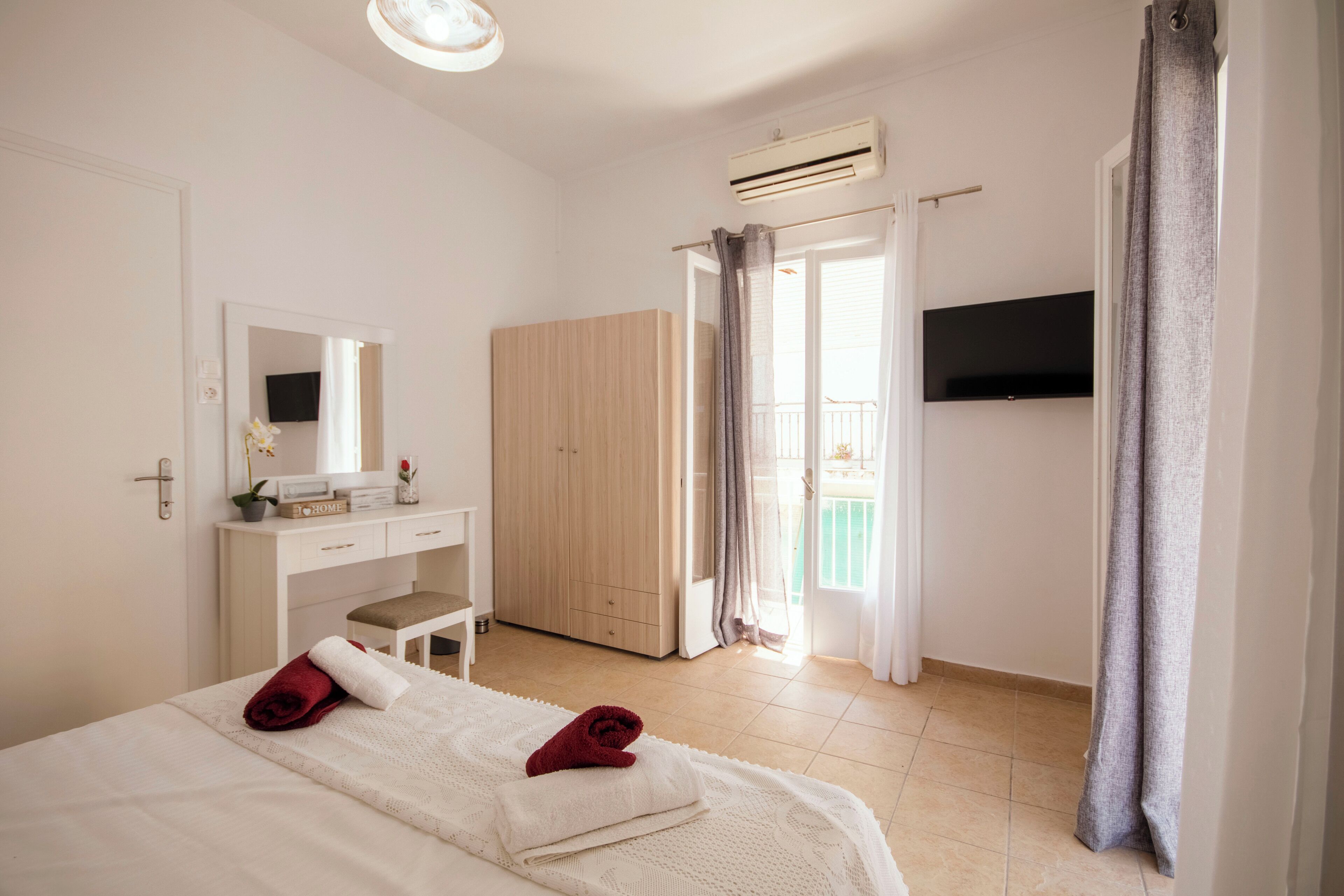Une chambre comprenant un lit, un bureau, une armoire, un climatiseur et un téléviseur.