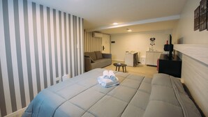 A hotel room with a large bed, a sofa, a small table, and a desk. - Maison Work & Travel 7 - Palermo  (Buenos Aires)