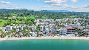 Guests can enjoy stunning views of the beach and lush hills from this coastal resort.
