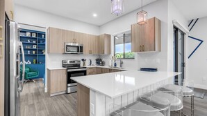 Une cuisine moderne avec des meubles en bois, un plan de travail blanc et un four encastré.