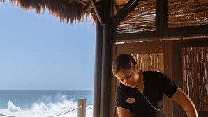 Sesión de masajes en una plataforma frente a la playa, con vista al océano.