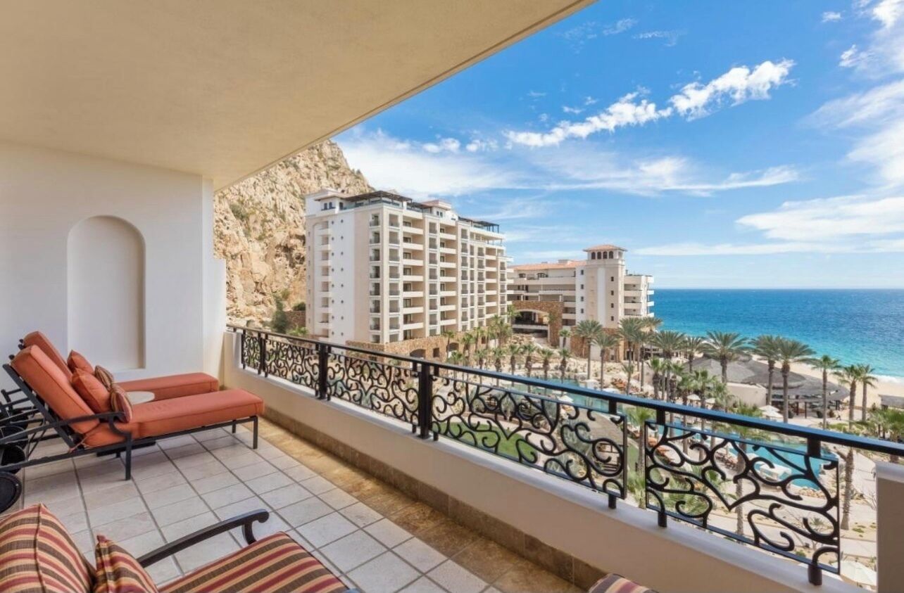 Un balcon avec vue sur la mer et un immeuble.