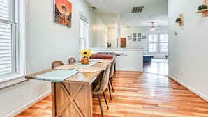 Un vaste espace dédié à la salle à manger, avec une table en bois, des chaises et un ventilateur de plafond.