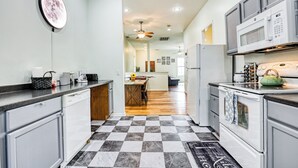 A kitchen with a checkered floor, white cabinets, a microwave, and a stove. - Stylish 2BR Minutes to Downtown - Prime Location (Savannah)