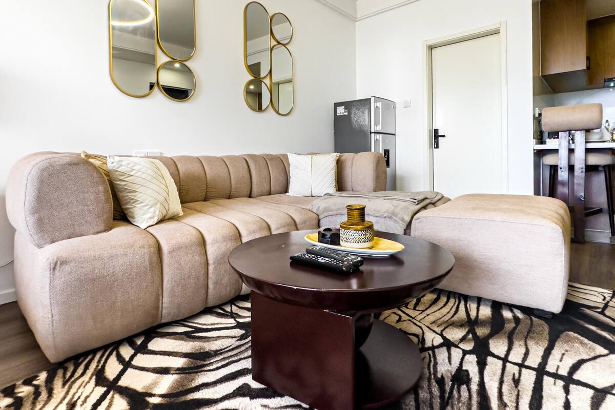 A modern living room with a sectional sofa, a round coffee table, and a zebra-patterned rug.