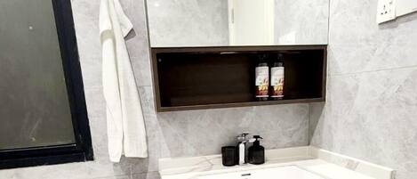A modern bathroom with a toilet, sink, and mirror.