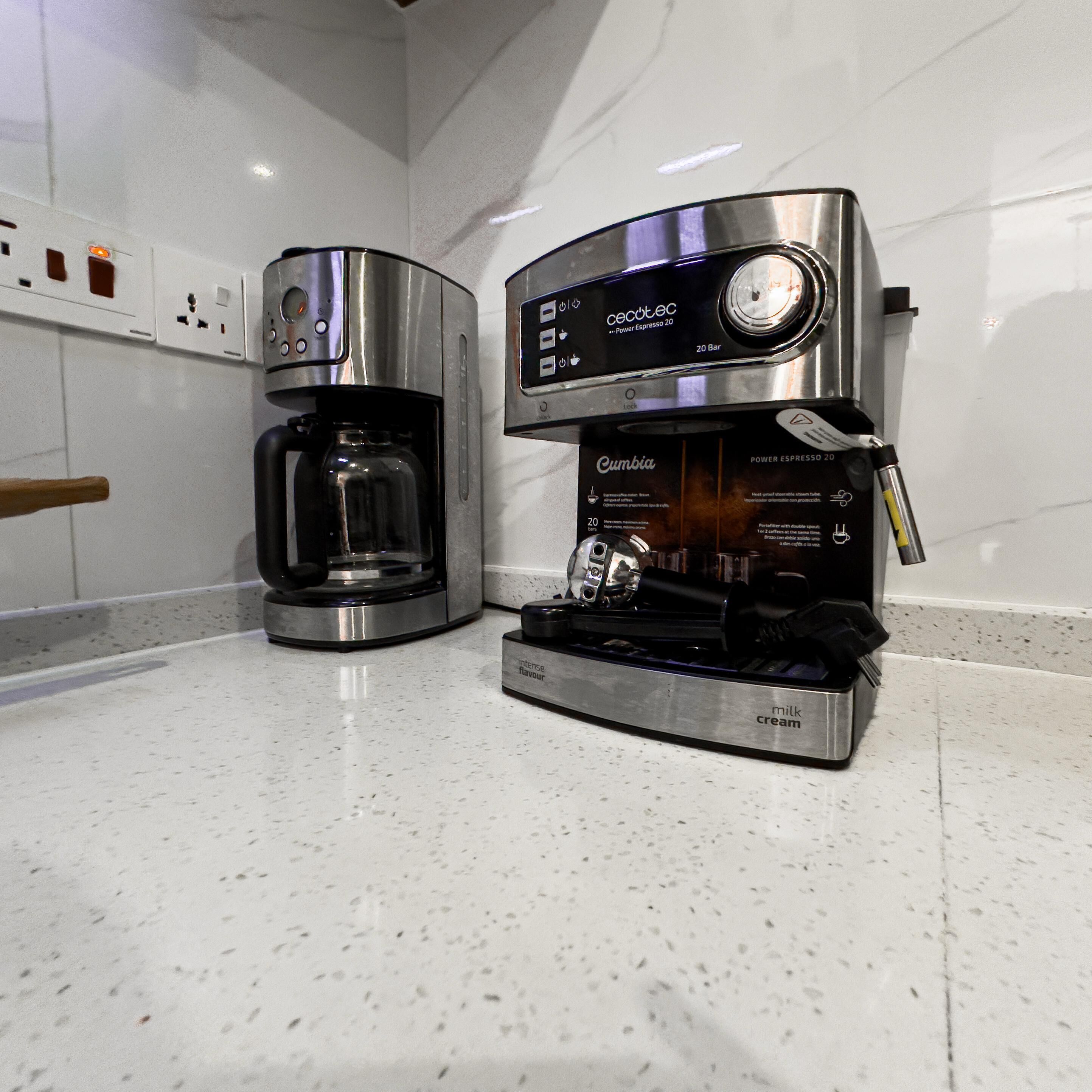 A kitchen with two coffee makers, one labeled 'Cecotec' and the other 'Cumbia'.