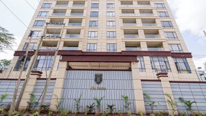 Un hotel moderno de gran altura con varios balcones y una entrada destacada.