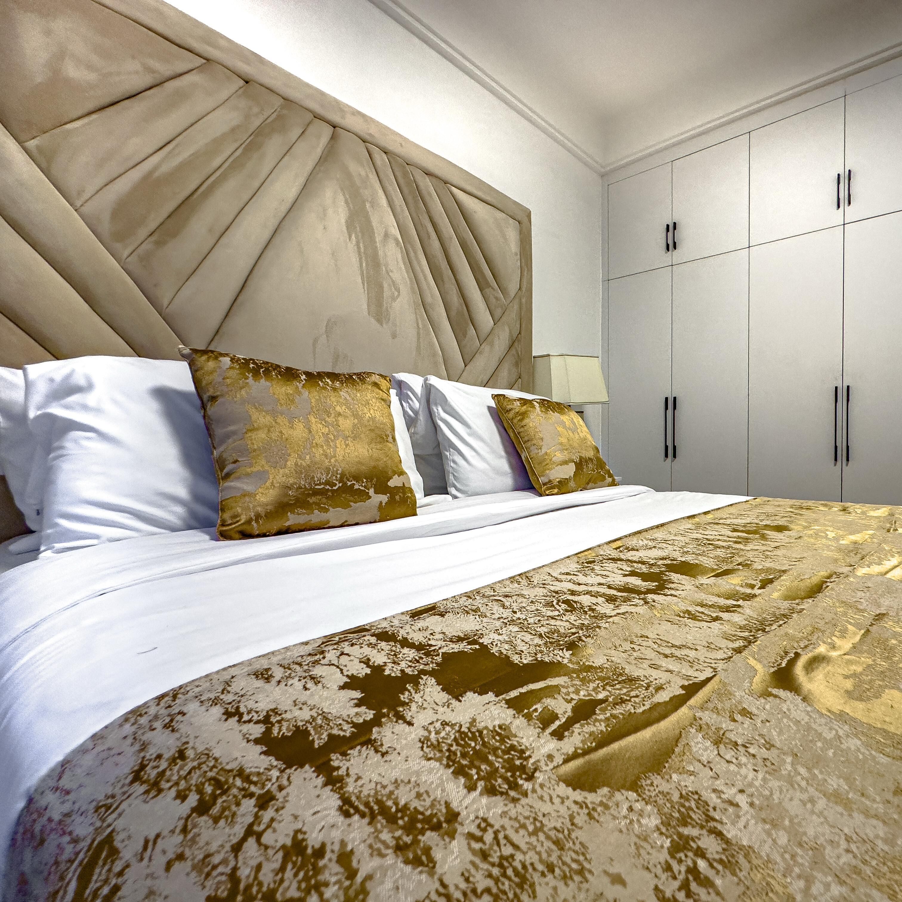 Una habitación de hotel con una cama grande, un cabecero y un armario.