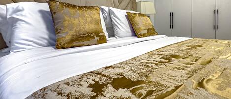 Una habitación de hotel con una cama grande, un cabecero y un armario.