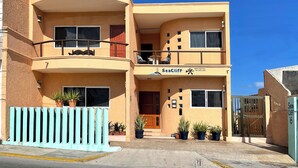 A two-story building with a balcony, potted plants, and a sign reading "SeaCliff". - SEA CLIFF, 4-bedroom Economical, Oceanfront House, Isla Mujeres (Isla Mujeres)