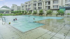 Ein Poolbereich mit mehreren Pools und einem angrenzenden Gebäude.