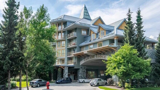 A multi-story hotel with a prominent entrance, balconies, and a stone facade.