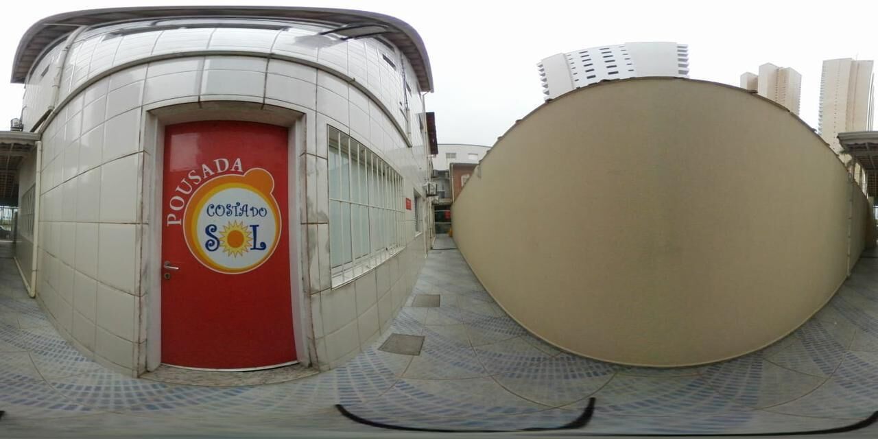 Un bâtiment avec une porte rouge portant l’inscription « Pousada Costa do Sol ».